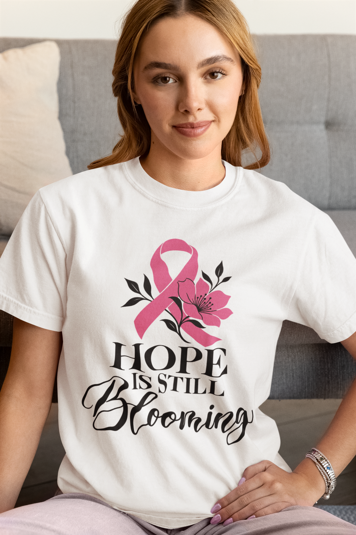 Smiling model wearing a light-colored tee with the “Hope Is Still Blooming” floral design.