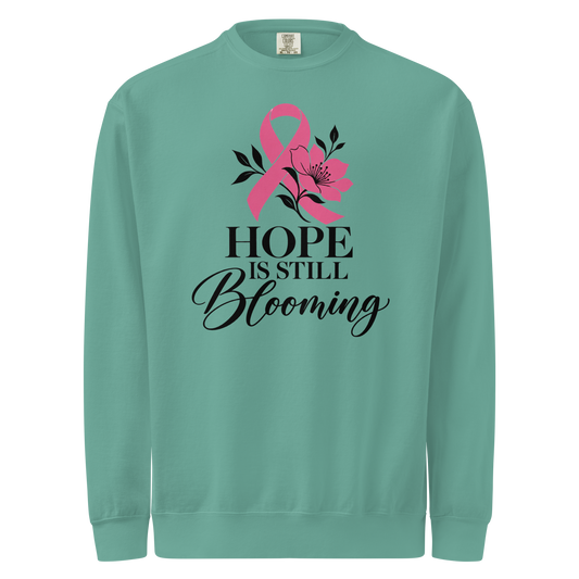 Seafoam sweatshirt with black “Hope Is Still Blooming” lettering, a pink awareness ribbon, and floral accents on the front