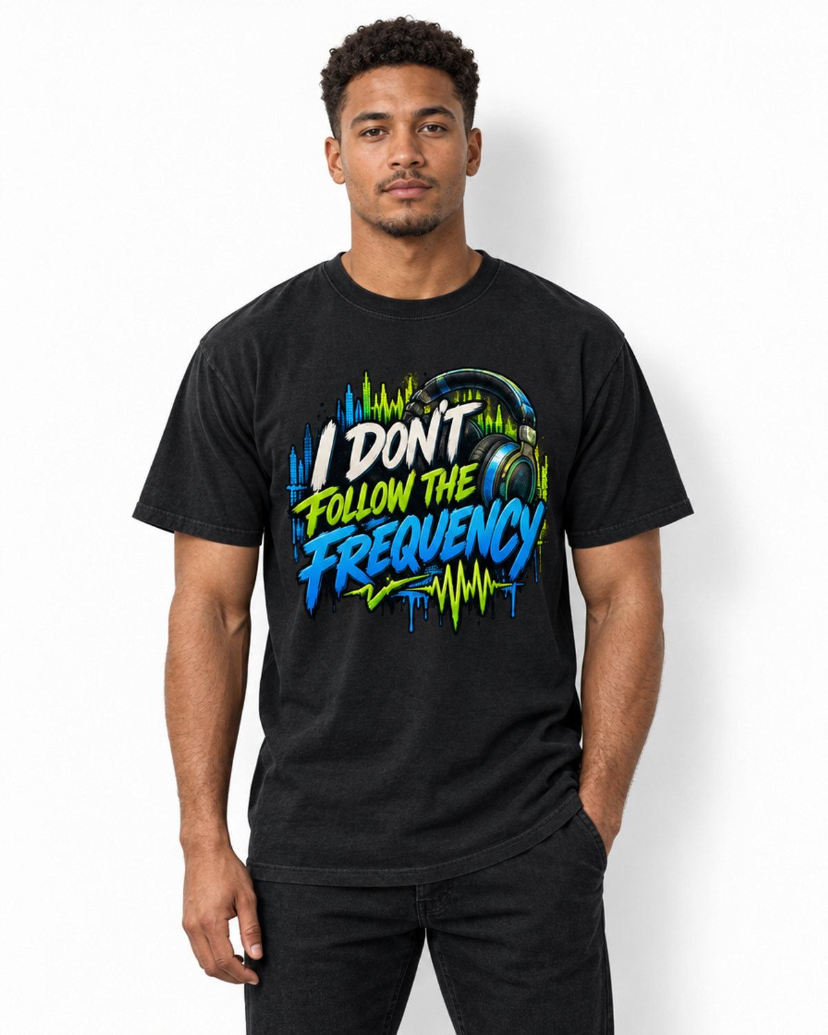 Male model wearing a black I Don’t Follow the Frequency tee with cream, lime, and blue lettering, headphones, and soundwave artwork.