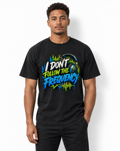 Male model wearing a black I Don’t Follow the Frequency tee with cream, lime, and blue lettering, headphones, and soundwave artwork.