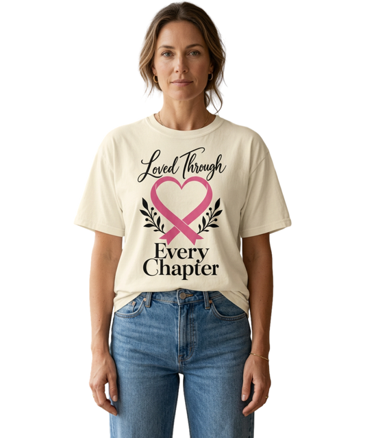 Model wearing an Ivory “Loved Through Every Chapter” pink ribbon tee with blue jeans.