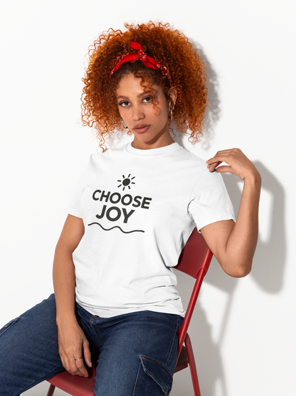 Woman wearing a white t-shirt with 'CHOOSE JOY' text, sitting on a red chair against a white background.