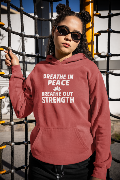 Person wearing a hoodie with 'Breathe in peace, breathe out strength' text in an outdoor setting.