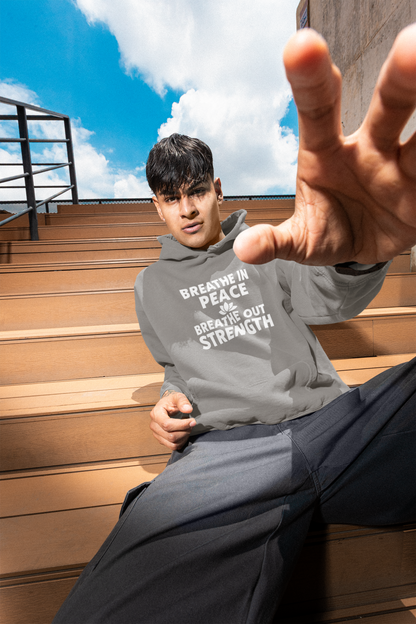 Person wearing a gray hoodie with text, sitting on wooden steps outdoors.