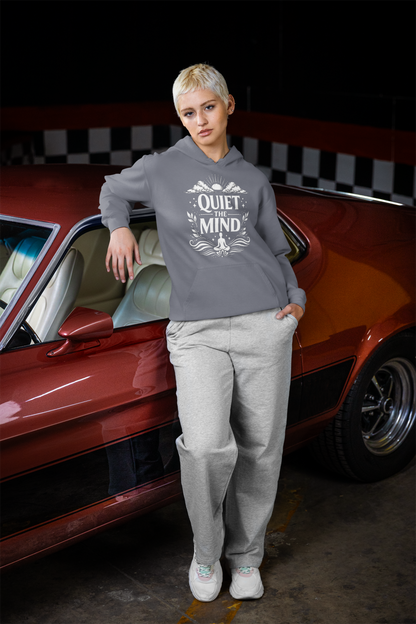 Person wearing a denim hoodie with 'Quiet the Mind' text, standing next to a red car in a garage.