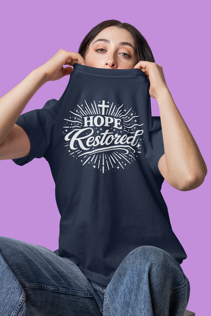 Person wearing a blue t-shirt with 'Hope Restored' design on a purple background