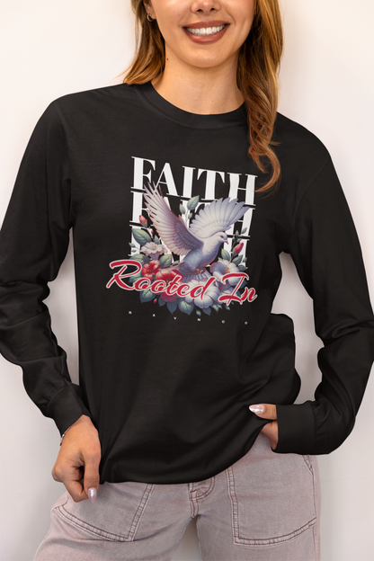 A woman wearing a black long-sleeve graphic t-shirt with a white dove, flowers, and the text 'FAITH ROOTED IN' on the front, paired with light gray jeans against a plain light background.