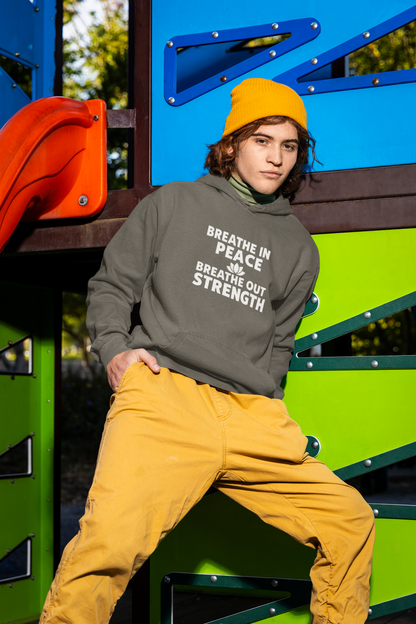 Person wearing a hoodie with a motivational quote in front of colorful playground equipment