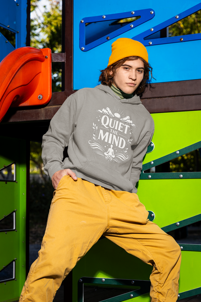 Person wearing a gray hoodie with text and mustard pants sitting on colorful playground equipment.