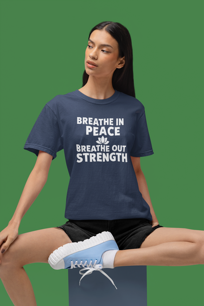 Person wearing a navy blue t-shirt with motivational text on a green background