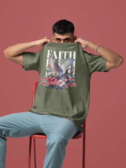 Person wearing a moss 'Rooted In Faith' garment-dyed tee featuring a dove and floral graphic.