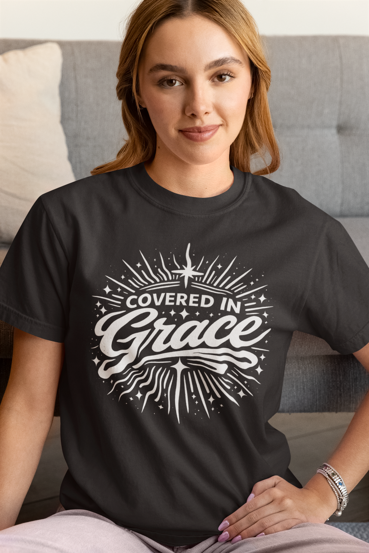 Woman wearing a black t-shirt with 'Covered in Grace' design.