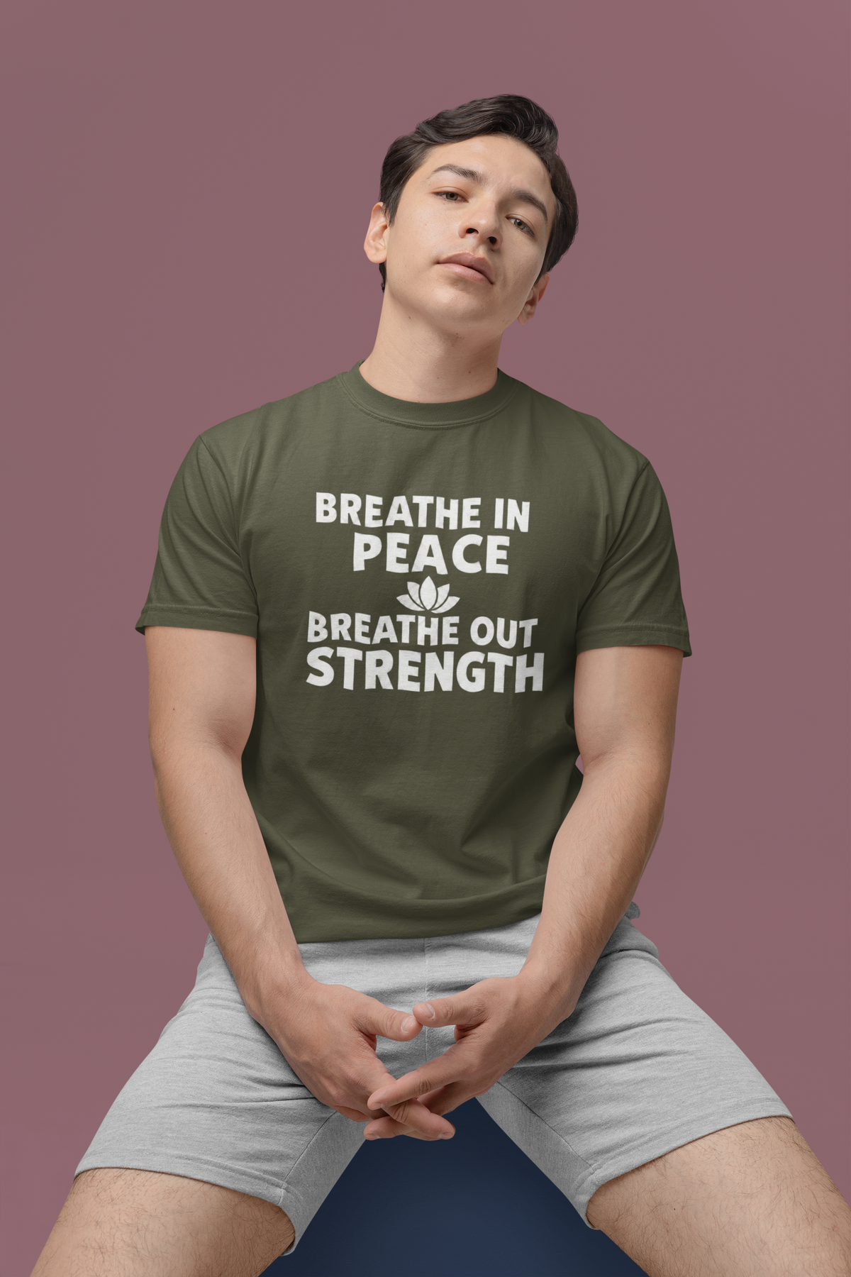 Person wearing a green t-shirt with motivational text on a purple background