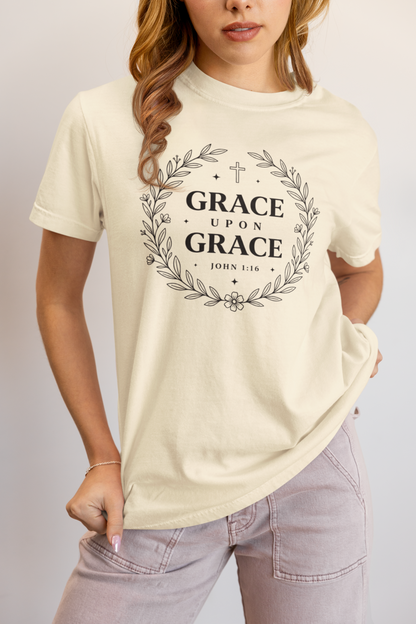 Person wearing an ivory t-shirt with 'Grace Upon Grace' text design.