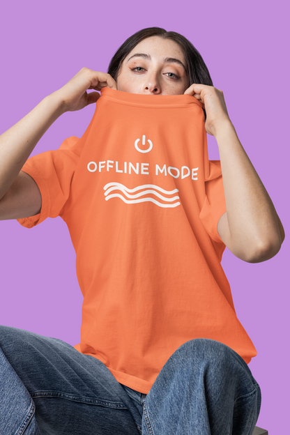 Person wearing an orange t-shirt with 'OFFLINE MODE' text on a purple background