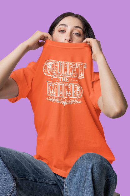 Person wearing an orange t-shirt with 'Quiet the Mind' text on a purple background