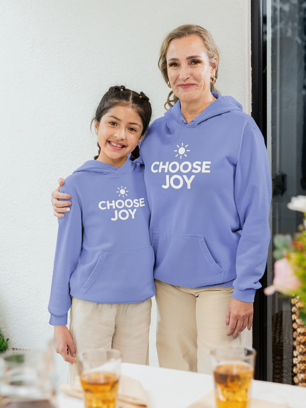 Two people wearing matching flo blue hoodies with 'CHOOSE JOY' text.