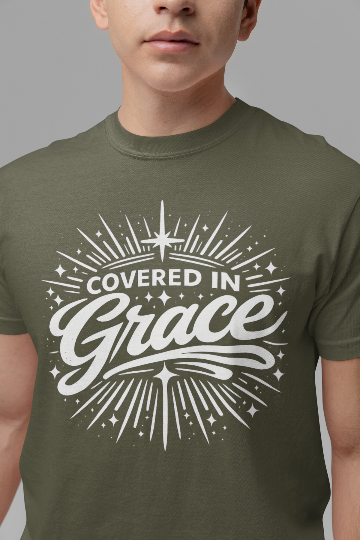 Person wearing a green t-shirt with 'Covered in Grace' text design.