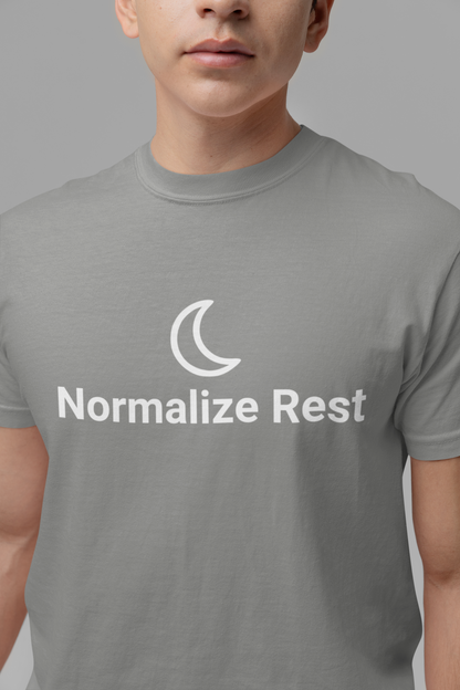 Person wearing a gray t-shirt with 'Normalize Rest' design on a plain background