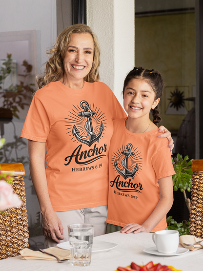 Woman and young girl wearing matching terracotta orange t-shirts with anchor design and text.