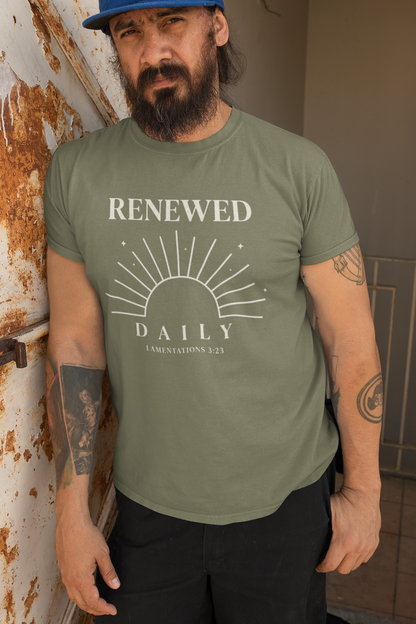 Man wearing a green t-shirt with 'RENEWED DAILY' text and design, standing against a rusty metal wall.