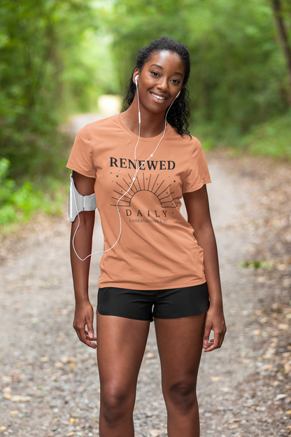 Woman wearing a 'Renewed Daily' t-shirt on a forest path