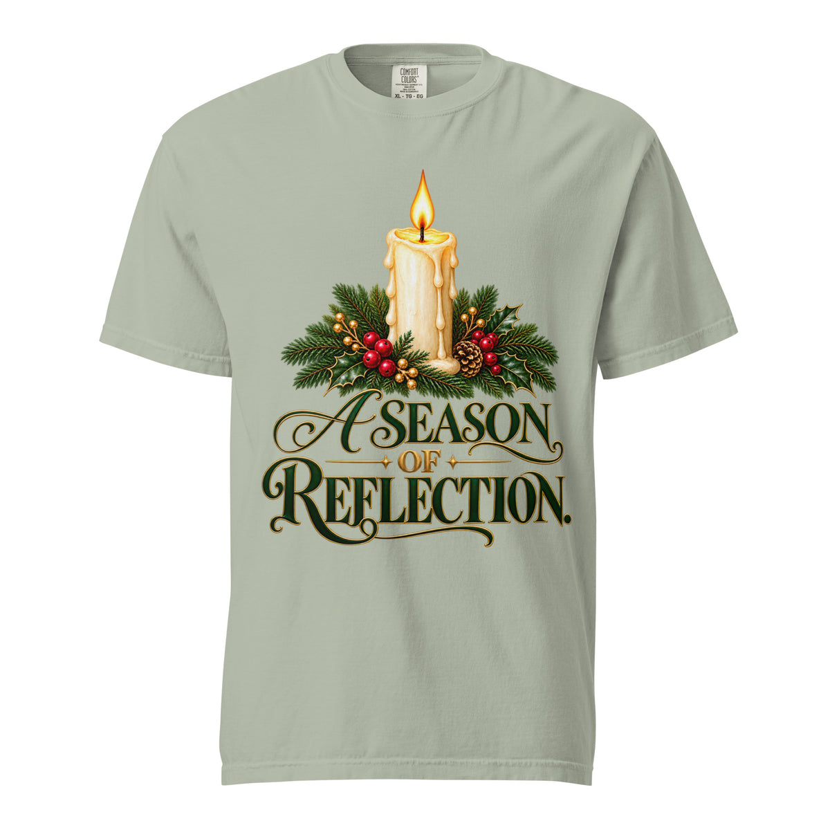 Man wearing an Ivory “A Season of Reflection” Christmas tee featuring a lit candle, evergreen branches, red berries, and green-and-gold lettering, paired with brown pants.