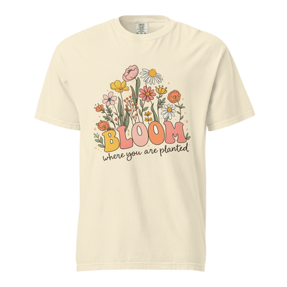 Flat mockup of an ivory 'Bloom Where You Are Planted' garment-dyed tee with wildflower garden graphic.