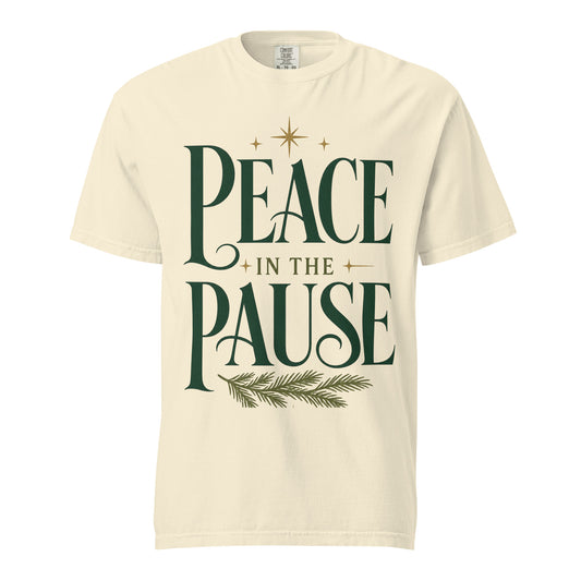 Front view of an Ivory Peace in the Pause Christmas tee featuring forest-green lettering, gold stars, and an evergreen sprig.