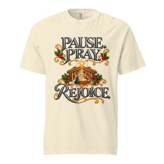Front view of an Ivory Pause. Pray. Rejoice. Christmas tee featuring a nativity scene, dark lettering, gold flourishes, greenery, and red berries.