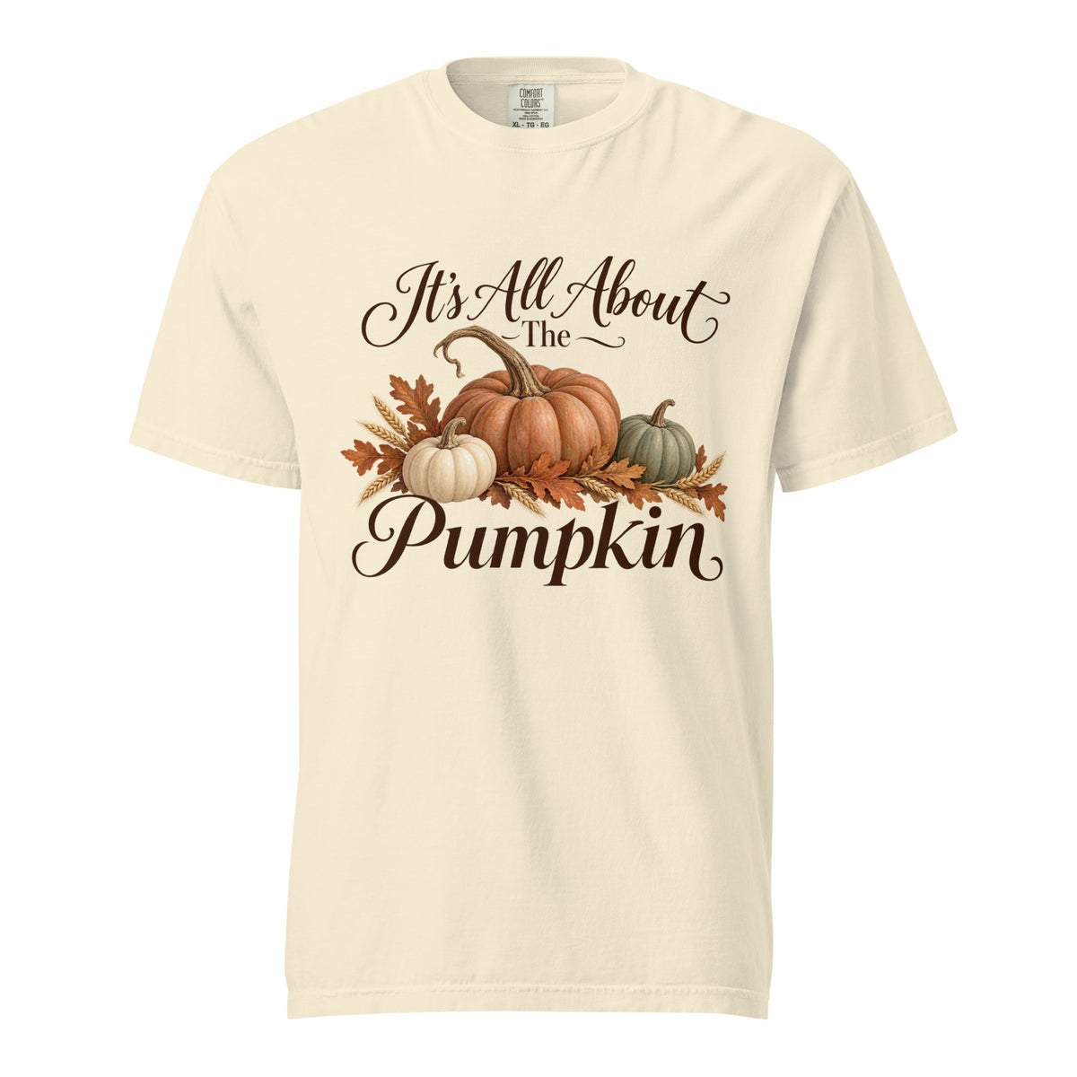 Ivory tee featuring ‘It’s All About the Pumpkin’ lettering, three pumpkins, autumn leaves, and wheat.