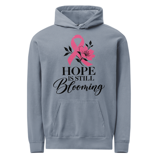 Blue Jean hoodie with black “Hope Is Still Blooming” lettering, a pink awareness ribbon, and floral accents on the front