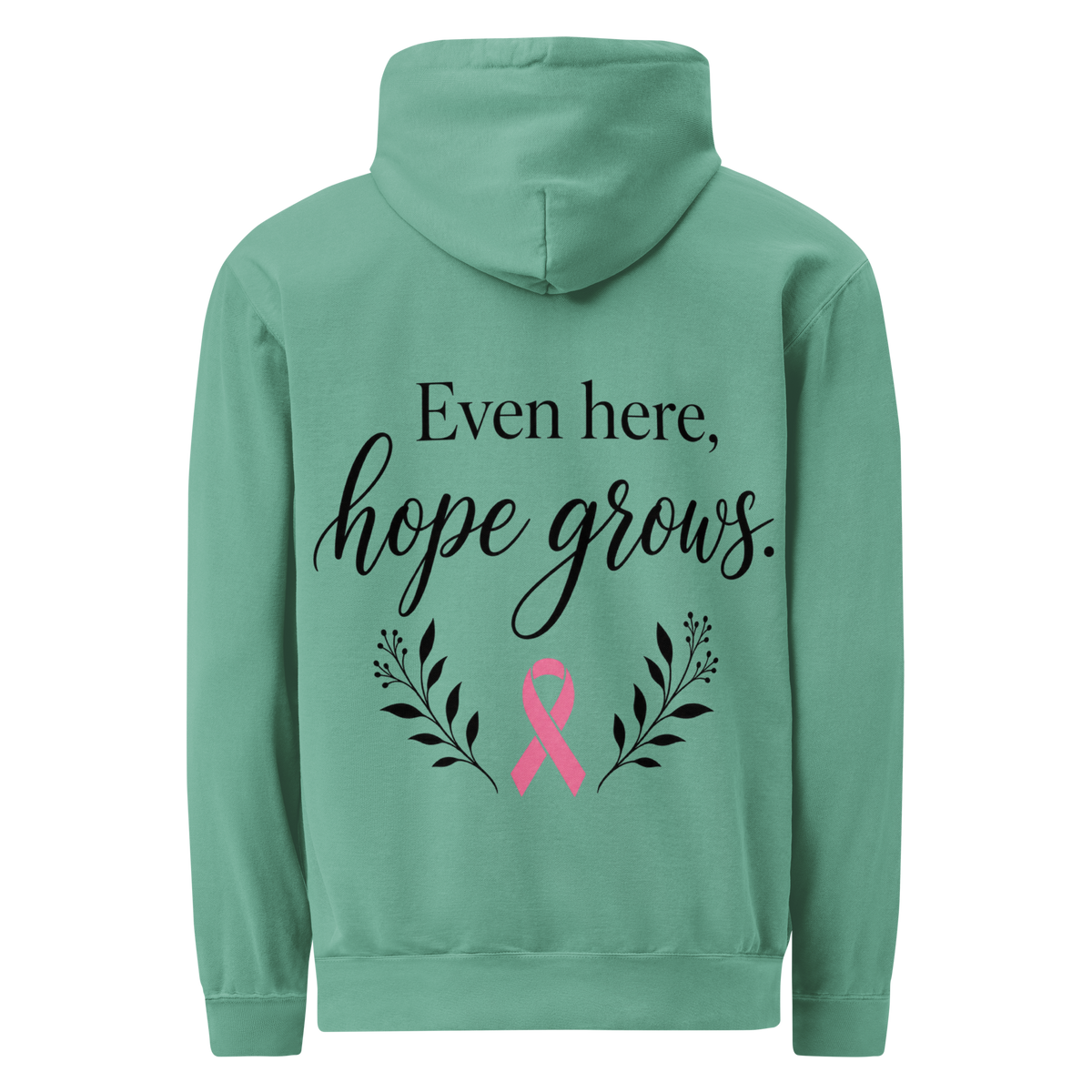 Seafoam hoodie back with black “Even here, hope grows.” lettering, a pink awareness ribbon, and botanical sprigs