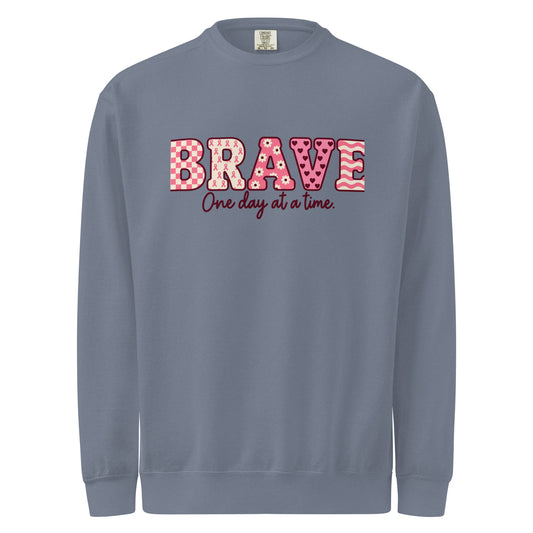 Blue Jean crewneck sweatshirt with pink patterned BRAVE lettering and “One day at a time” on the front