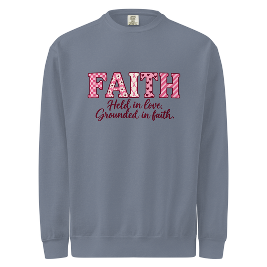 Blue Jean crewneck sweatshirt with pink patterned FAITH lettering and “Held in love. Grounded in faith.” on the front