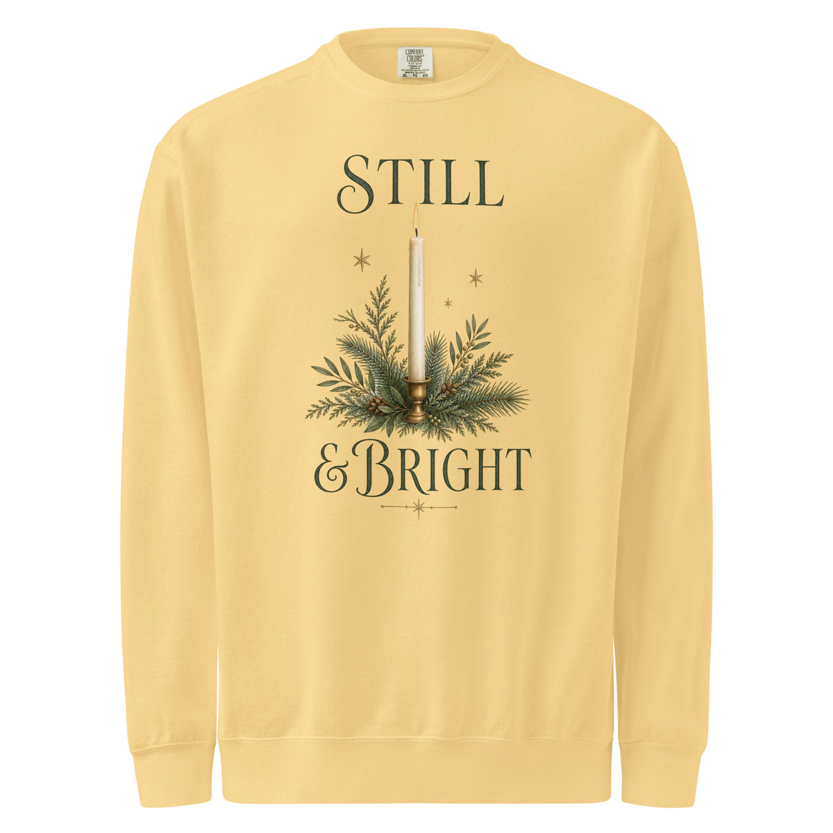 Butter yellow Still & Bright Christmas sweatshirt with a candle, evergreen branches, gold stars, and dark green lettering.