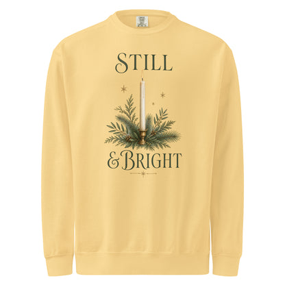Butter yellow Still & Bright Christmas sweatshirt with a candle, evergreen branches, gold stars, and dark green lettering.