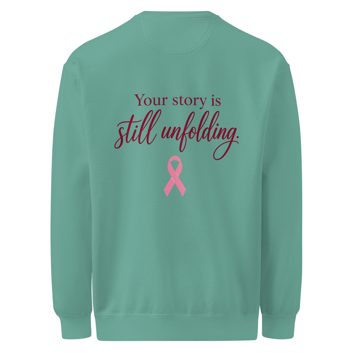 Back of Seafoam sweatshirt with burgundy “Your story is still unfolding” lettering above a pink breast cancer awareness ribbon.