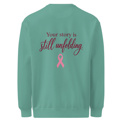 Back of Seafoam sweatshirt with burgundy “Your story is still unfolding” lettering above a pink breast cancer awareness ribbon.