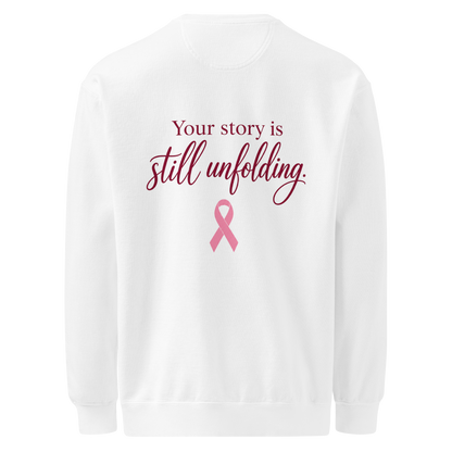 Back of white sweatshirt with burgundy “Your story is still unfolding” lettering above a pink breast cancer awareness ribbon.