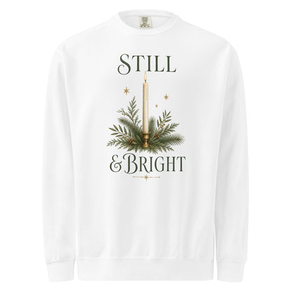 White Still & Bright Christmas sweatshirt with a candle, evergreen branches, gold stars, and dark green lettering.